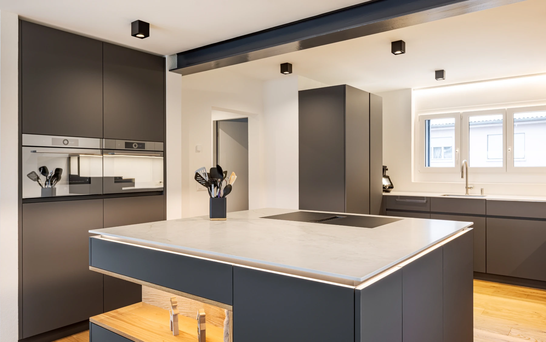 Kochinsel mit Keramikabdeckung und integrierter Lichtlinie.