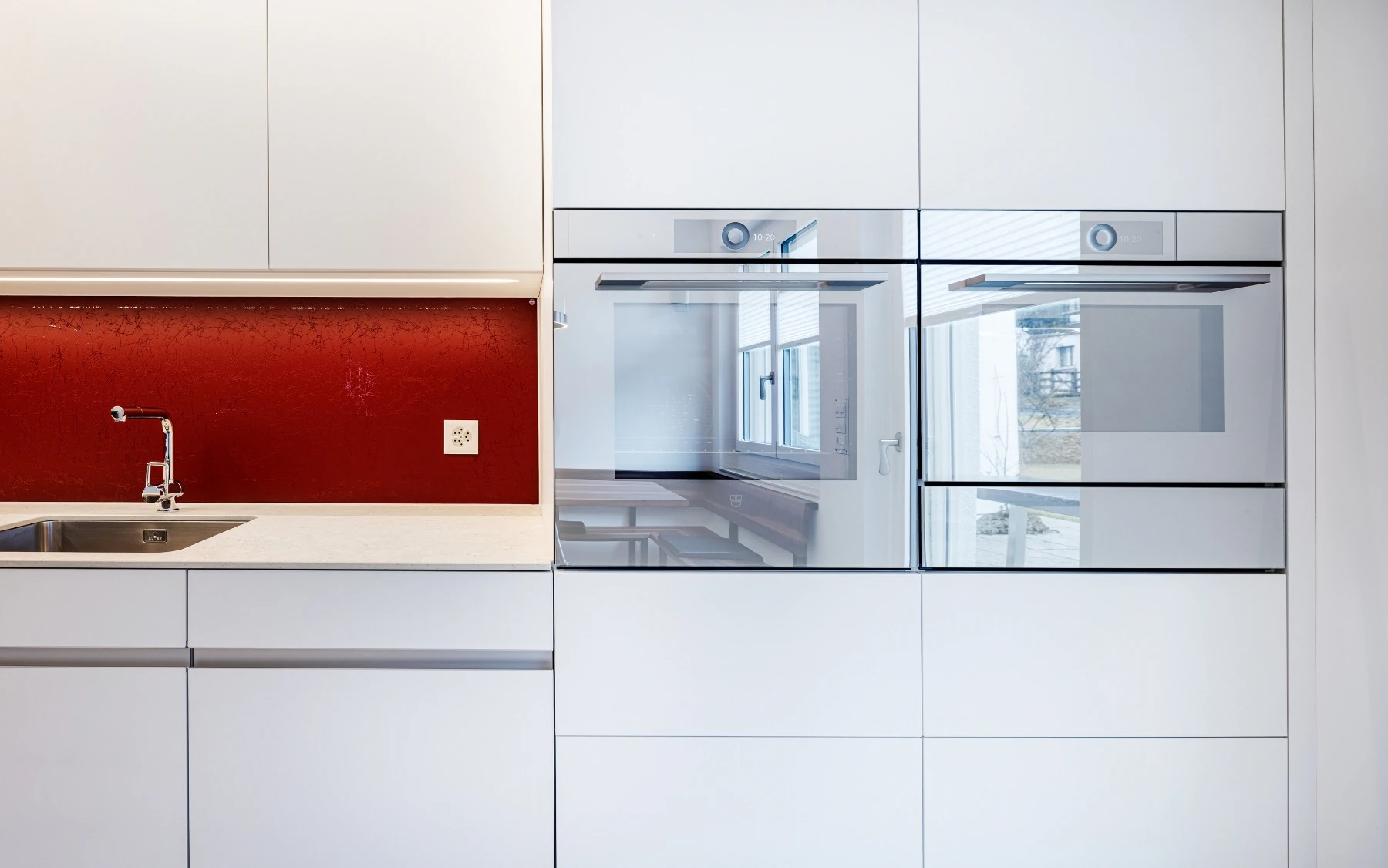 Hochschränke mit integrierten Geräten und Aluminium Griffprofilen