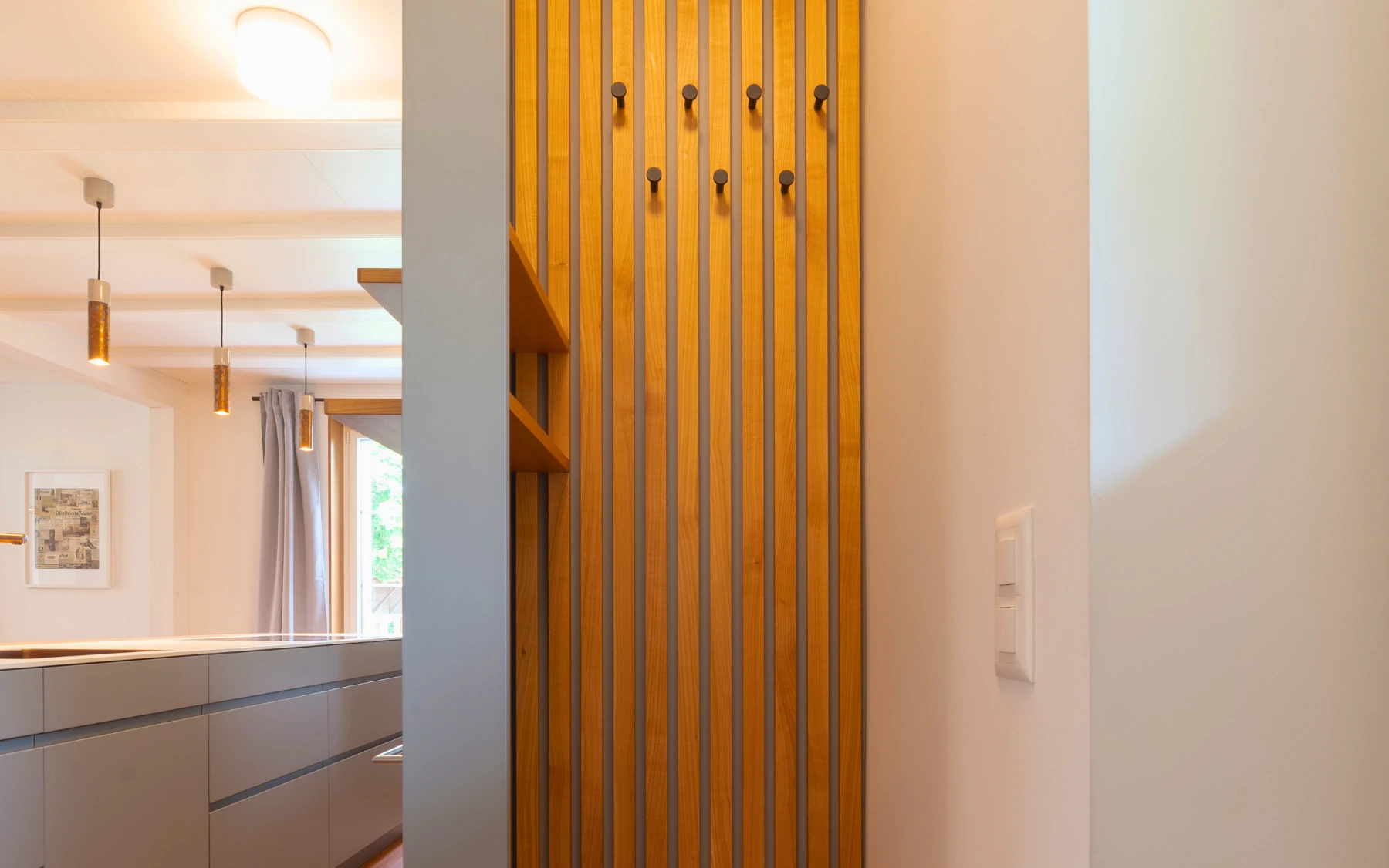 Garderobenlösung mit vertikaler Struktur und integrierten Haken.